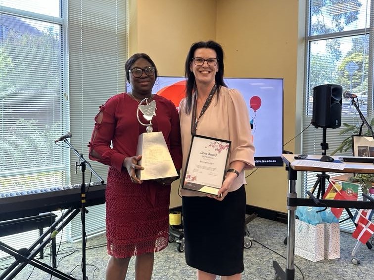 2 people in a music room holding certificates