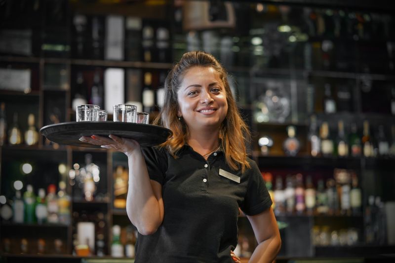 Person with a glass of whisky on a serving plate