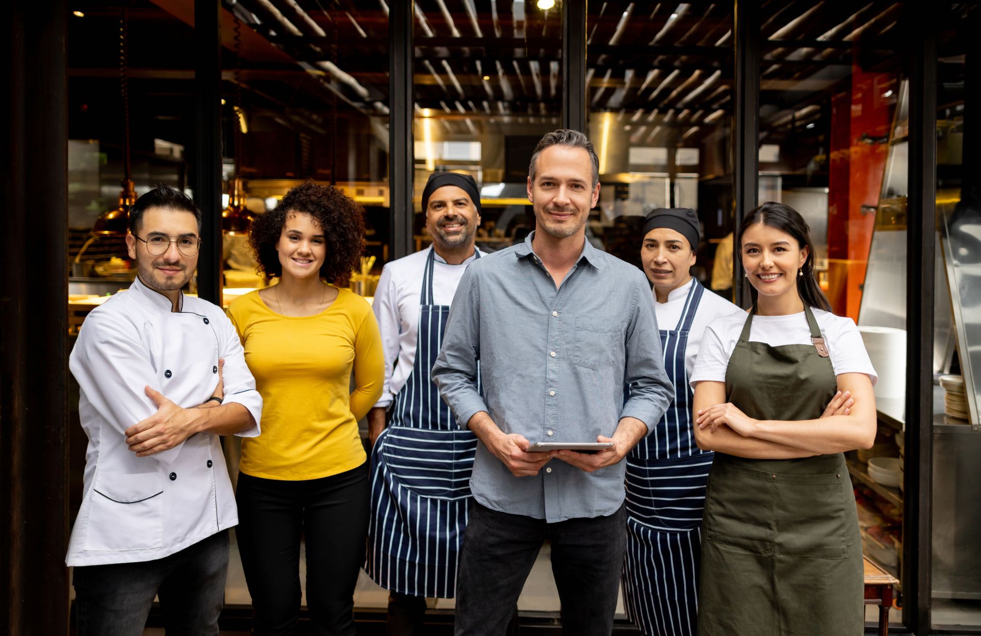 Group of hospitality workers standing in front of restaurant window