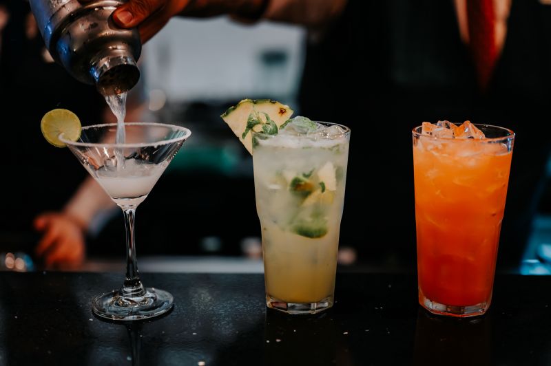 3 cocktails sitting on a bar