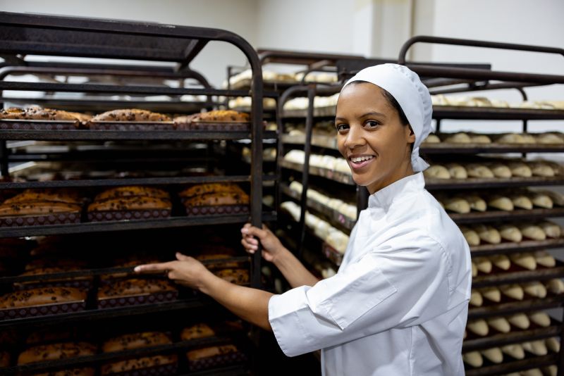 Woman standing in front of racks of bread