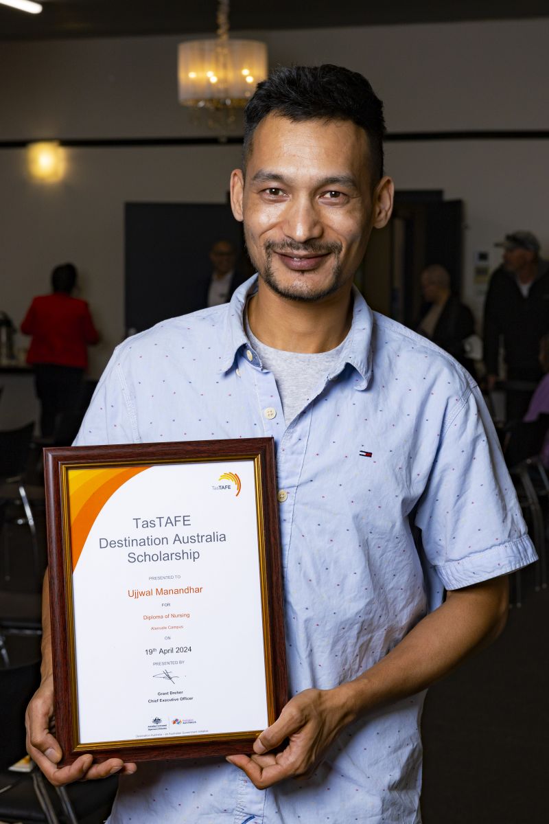 man holding a framed certificate